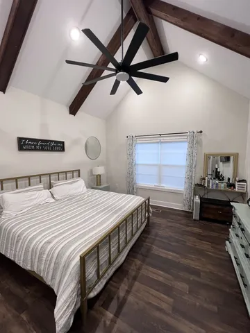 a bedroom with a bed and a flat tv screen on the dresser