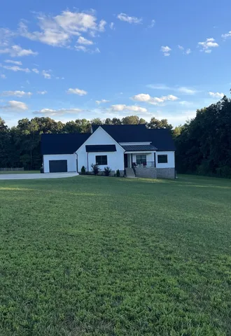 a view of a house with a yard and sitting area