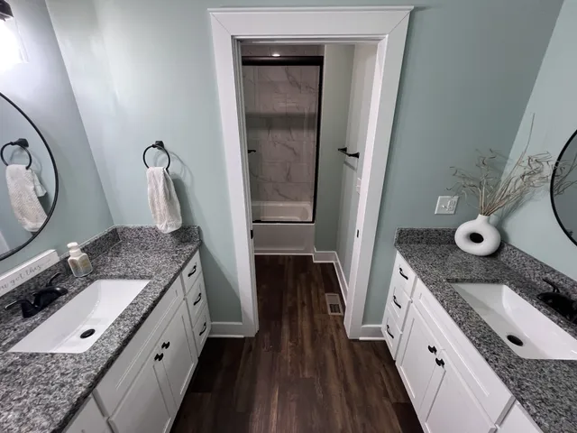 a bathroom with a granite countertop sink a mirror and vanity