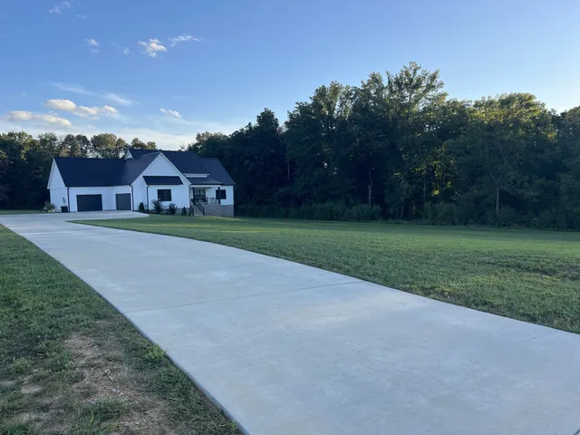 a front view of a house with a yard and trees