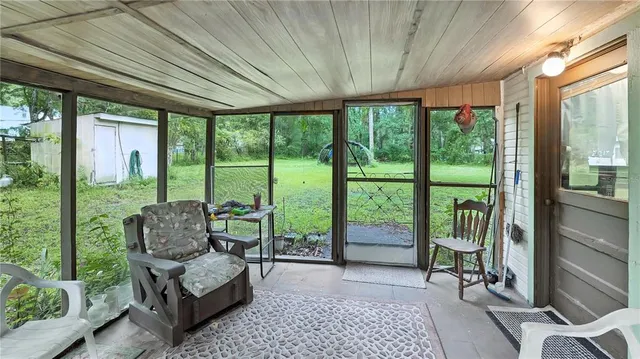 a living room with furniture and a floor to ceiling window