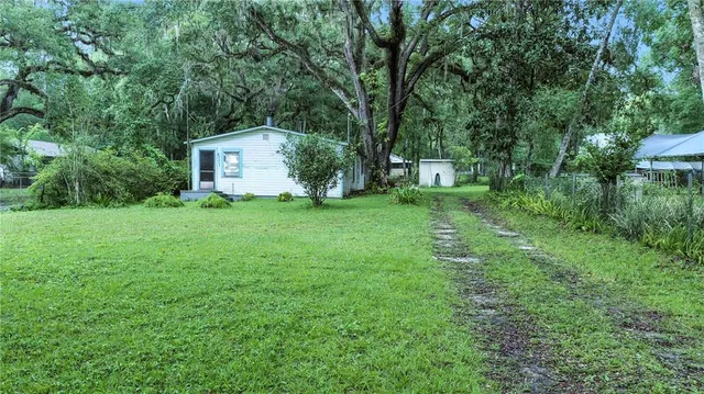 a front view of a house with a yard and trees