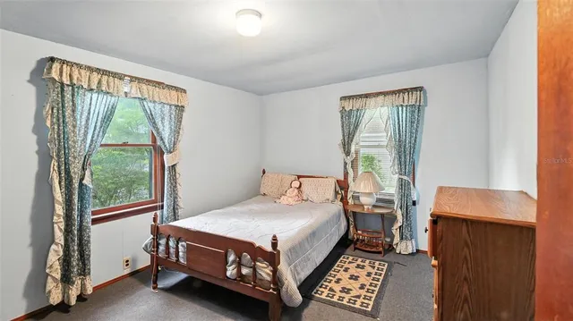 a bed sitting in a bedroom next to a window