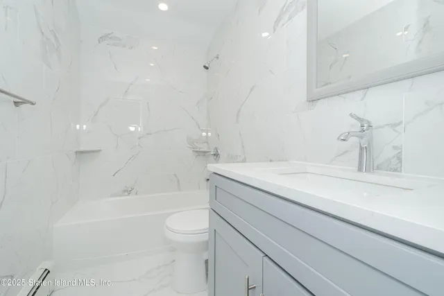 a bathroom with a granite countertop sink a toilet and bathtub
