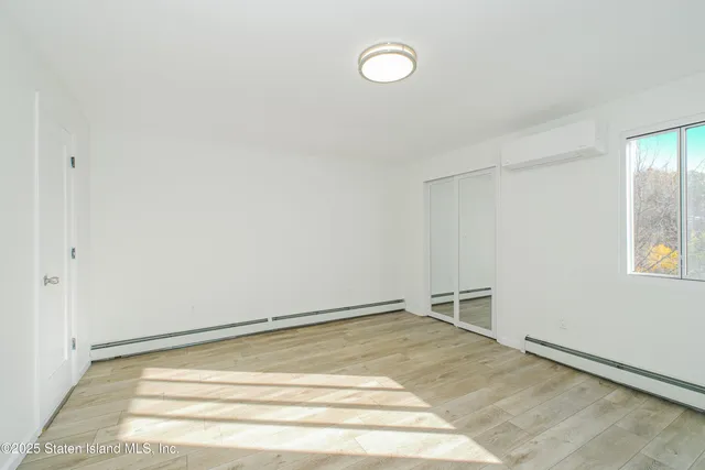 a view of a room with wooden floor and windows