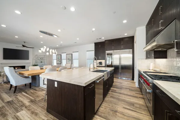 a large kitchen with stainless steel appliances a large counter top space a sink a stove and a refrigerator