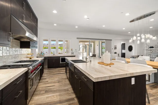 a large kitchen with stainless steel appliances a sink and a stove
