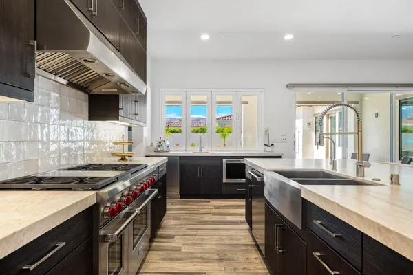a kitchen with stainless steel appliances granite countertop a sink and a stove