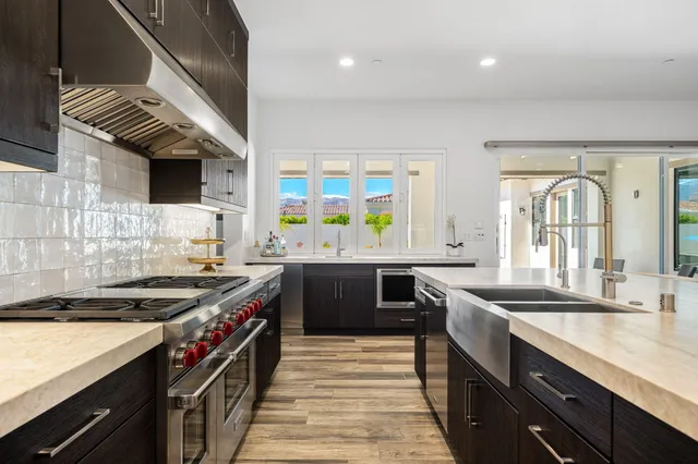 a kitchen with stainless steel appliances granite countertop a sink and a stove