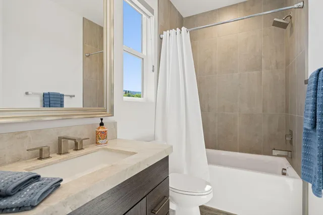 a bathroom with a granite countertop toilet a sink and a mirror