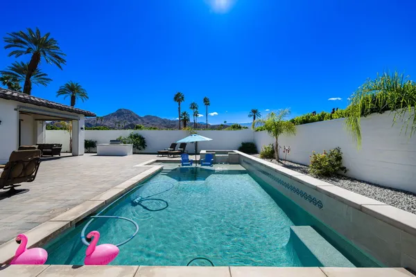 a view of a patio with couches table and chairs and potted plants