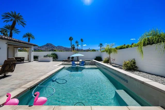 a view of a patio with couches table and chairs and potted plants