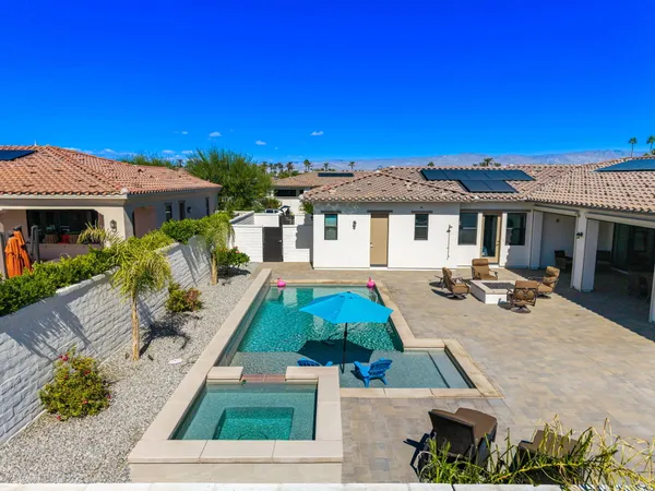 a view of a house with pool and chairs