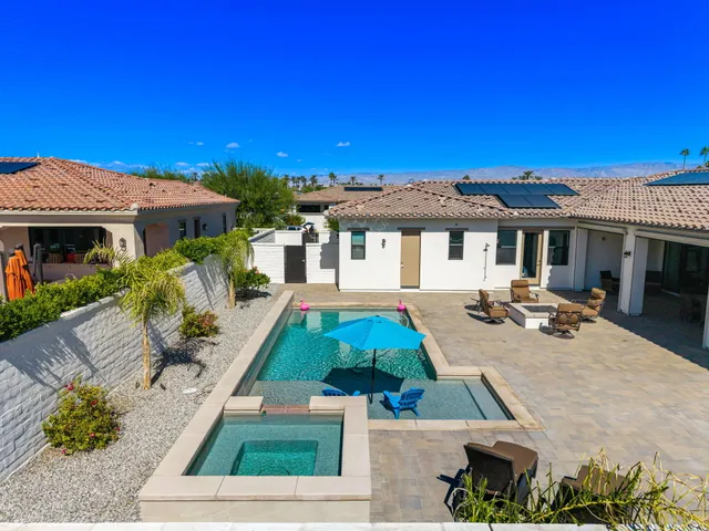a view of a house with pool and chairs