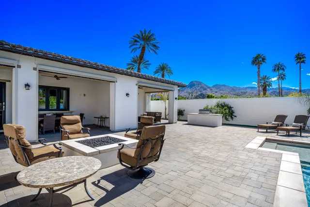a dining room with furniture and a floor to ceiling window