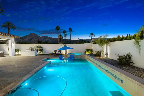 a view of a house with swimming pool and sitting area