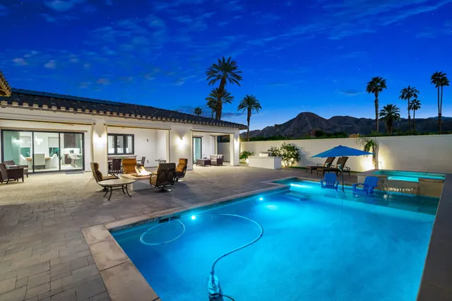 a swimming pool with outdoor seating and yard
