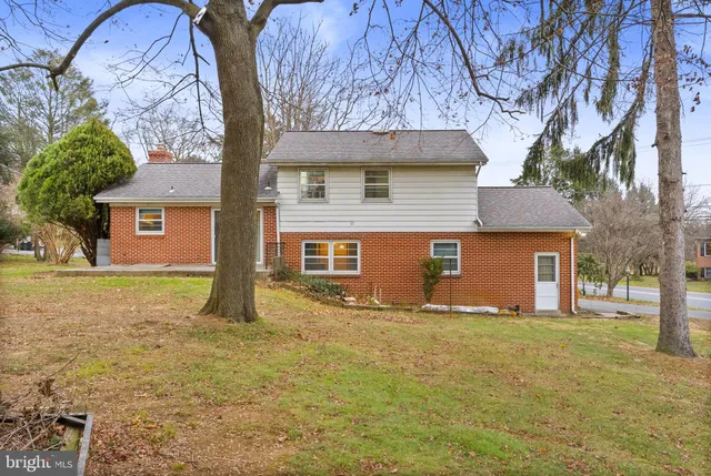 a yellow house with trees in front of it