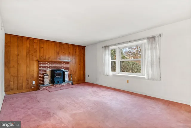 an empty room with fireplace and windows