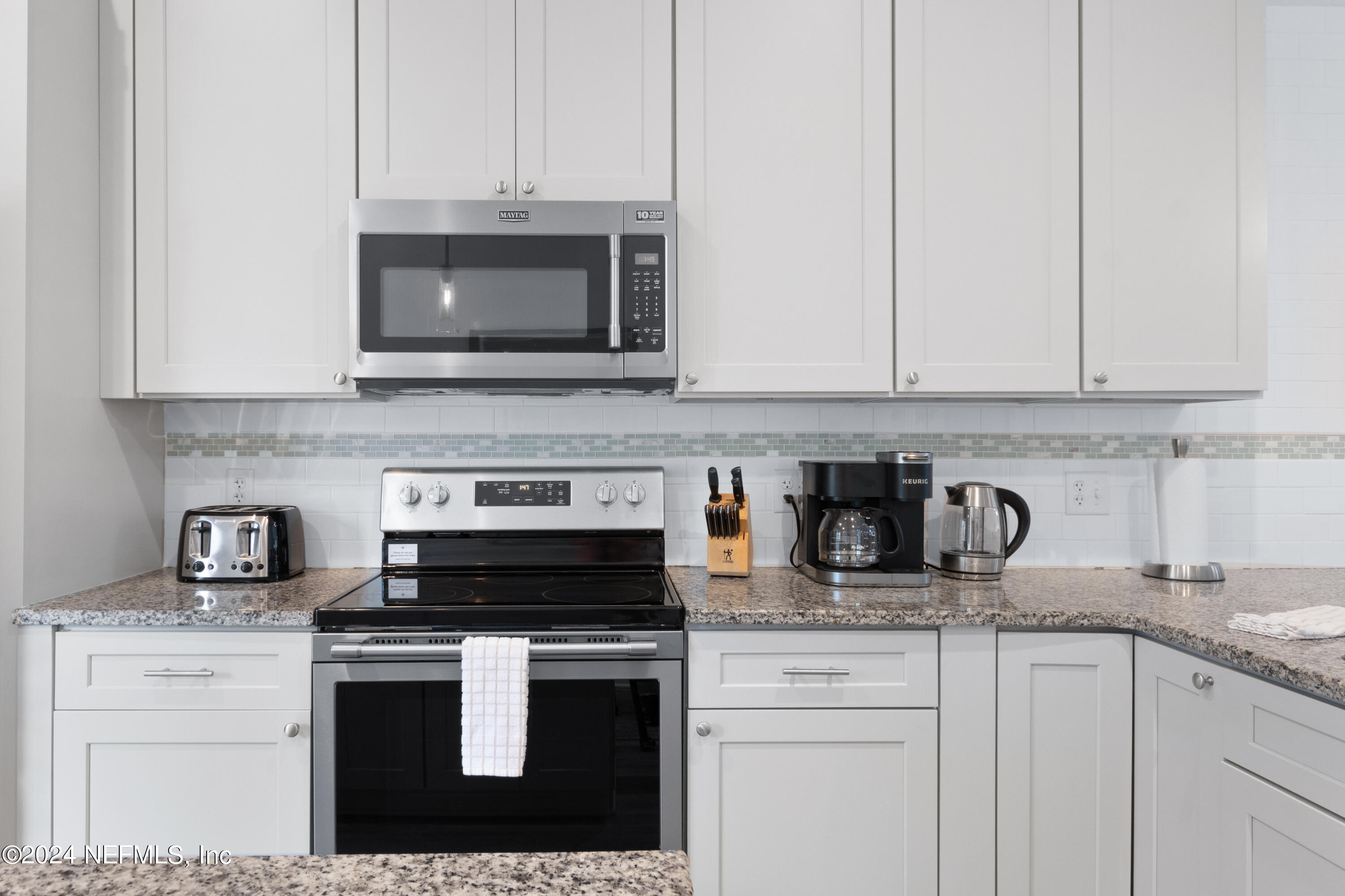 603 Boating Club Road St. Augustine, FL 32084 - Photo 16 of 32 a kitchen with granite countertop white cabinets and appliances