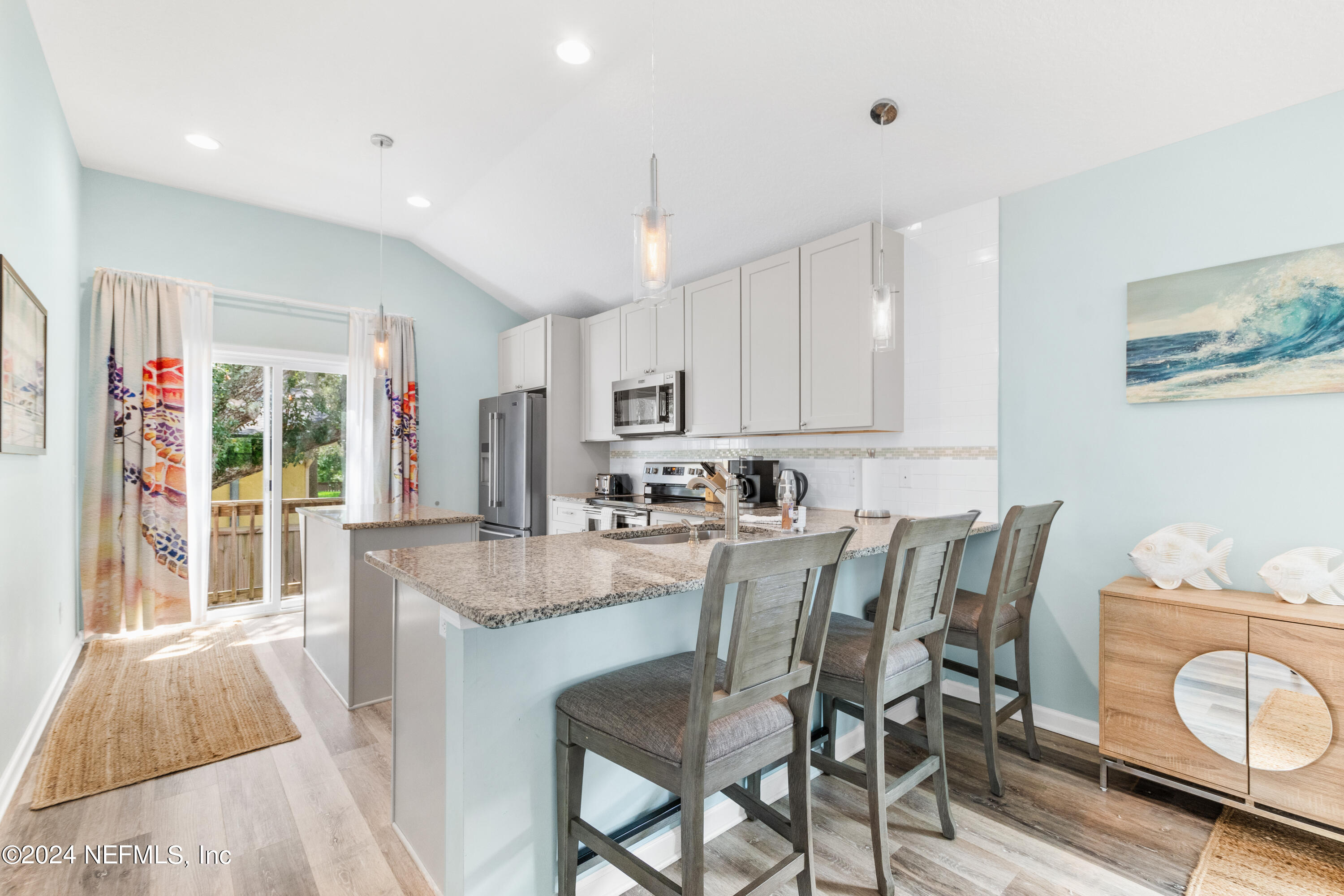 603 Boating Club Road St. Augustine, FL 32084 - Photo 9 of 32 a dining table with kitchen island granite countertop furniture and a view of kitchen