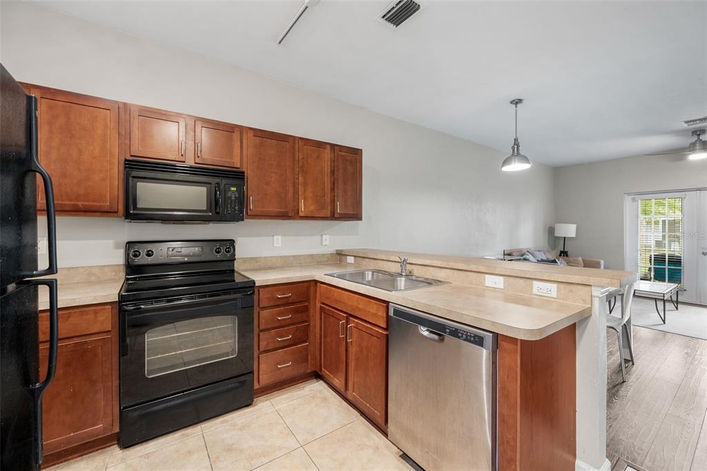 2927 Southwest 35th Place, Unit 113 Gainesville, FL 32608 - Photo 6 of 27 a kitchen with a sink stove and microwave