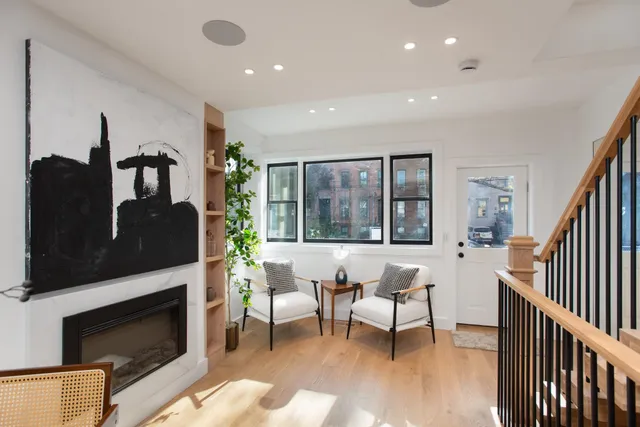 a living room with furniture a fireplace and a large window