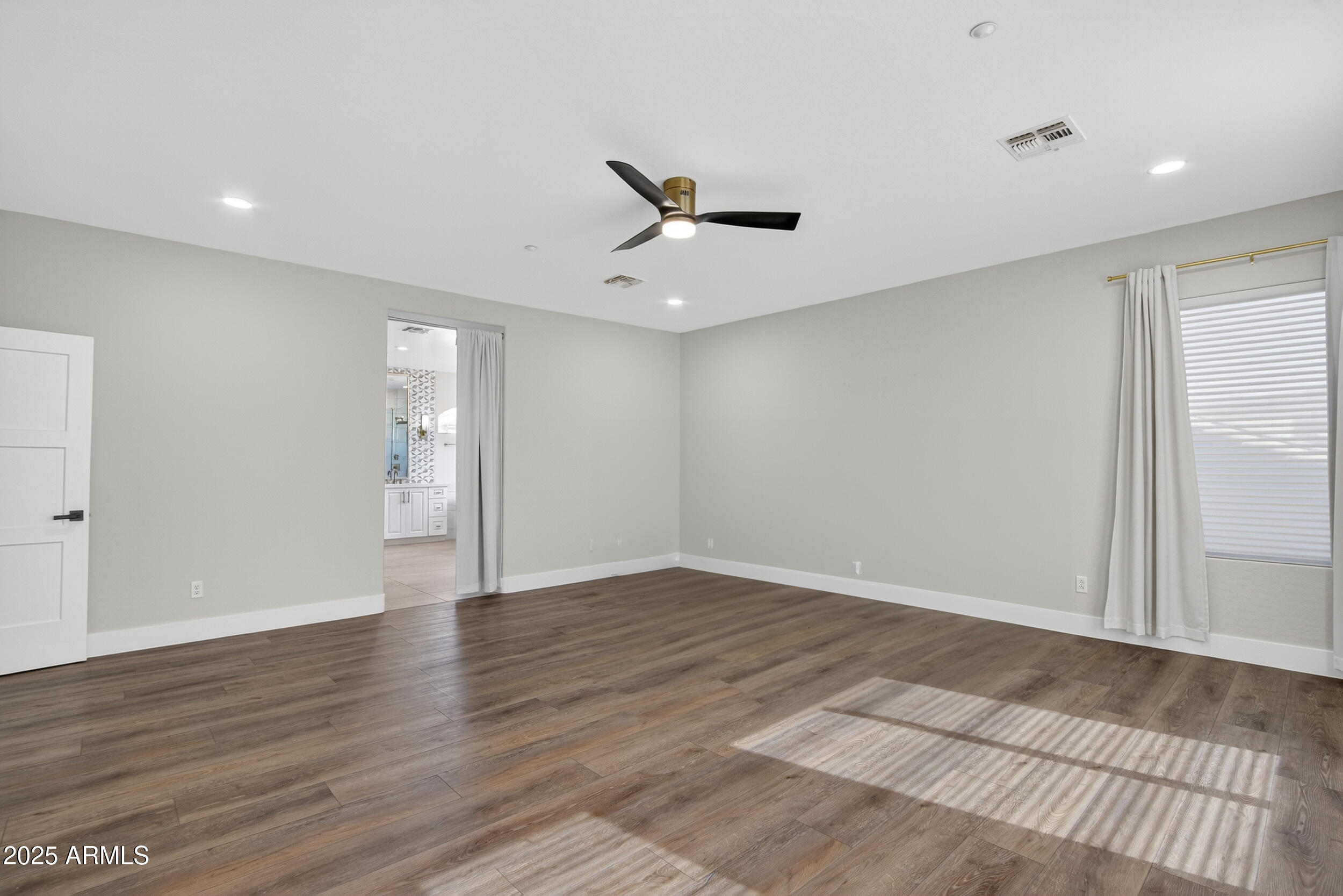 10587 East Sheena Drive Scottsdale, AZ 85255 - Photo 28 of 56 a view of an empty room with wooden floor and a ceiling fan