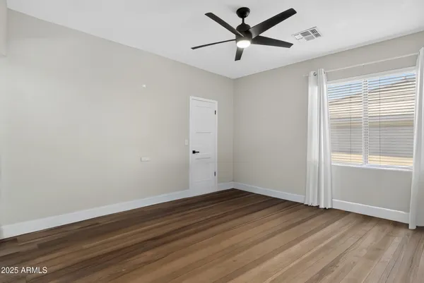 wooden floor fireplace and windows in an empty room