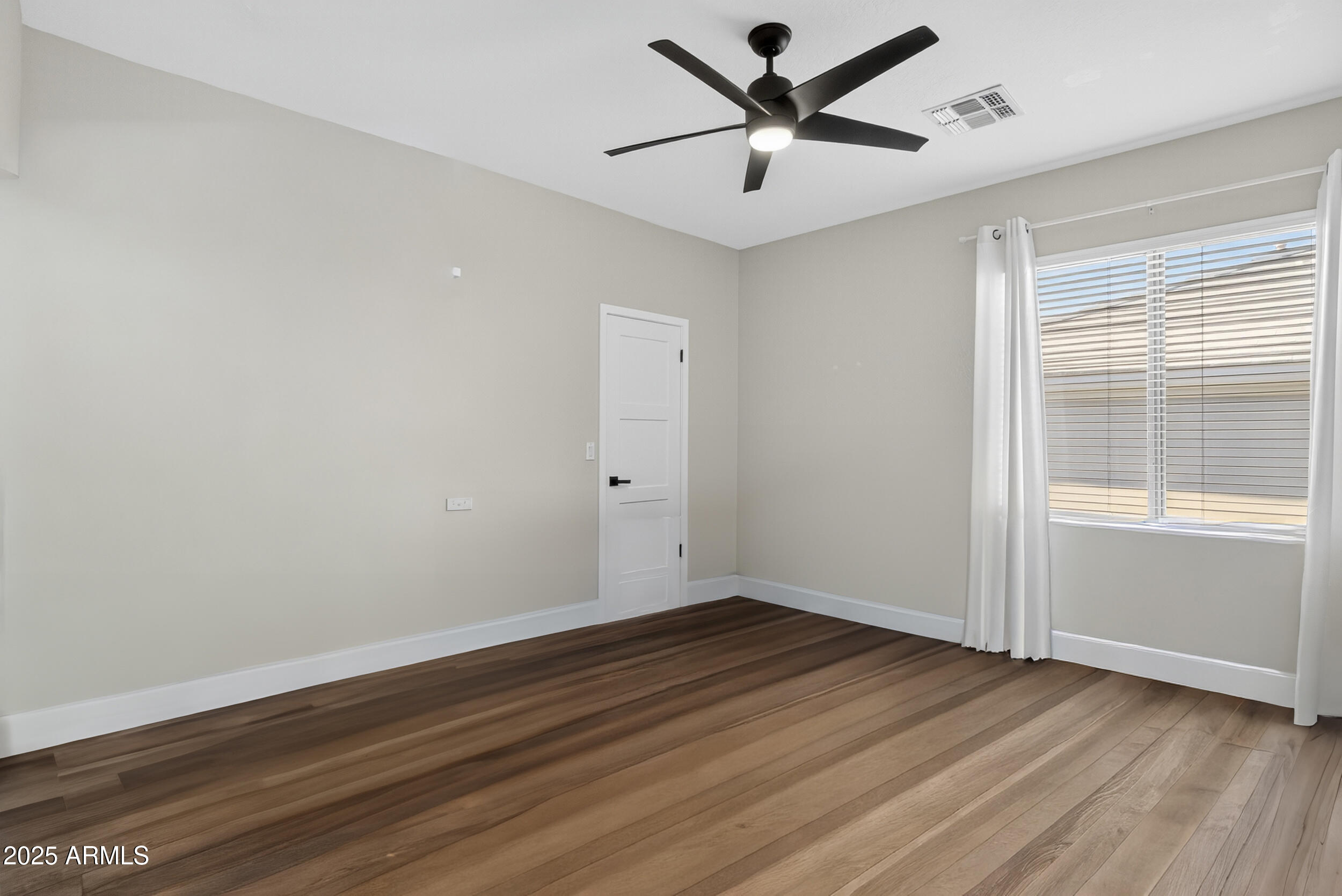 10587 East Sheena Drive Scottsdale, AZ 85255 - Photo 36 of 56 an empty room with wooden floor and windows