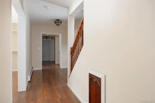 a view of a hallway with wooden floor and entryway