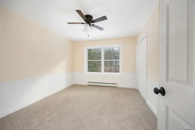 an empty room with a window and a ceiling fan