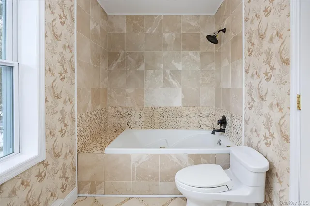 a white bath tub sitting next to a white toilet