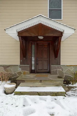 a front view of a house with a yard covered in snow