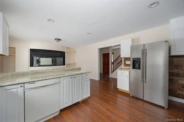 a kitchen with granite countertop a refrigerator and a sink