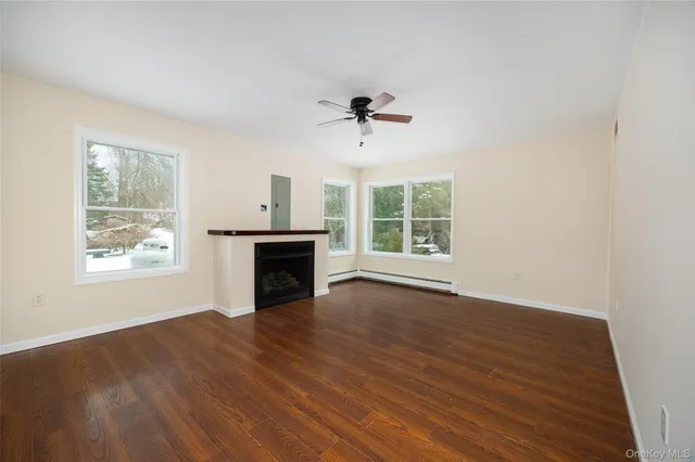 wooden floor fireplace and windows in an empty room