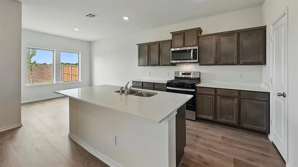a kitchen with stainless steel appliances a sink microwave and stove
