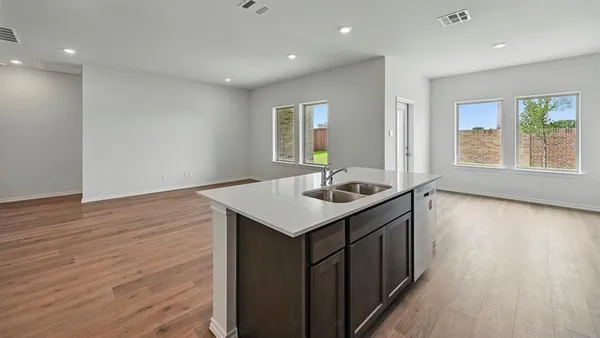a kitchen with a sink cabinets and wooden floor