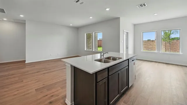 a kitchen with a sink cabinets and wooden floor