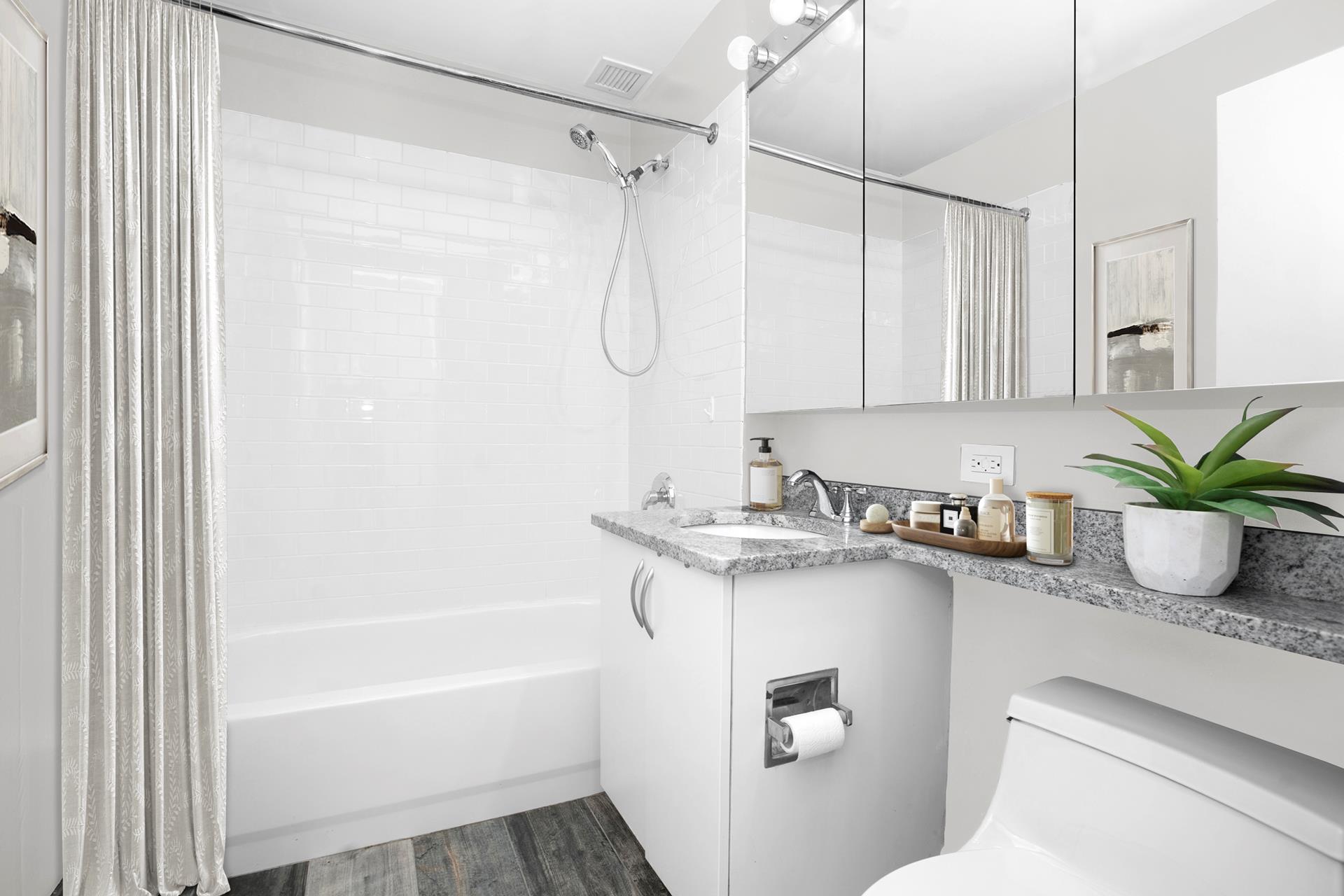 199 Bowery, Unit 2A Manhattan, NY 10002 - Photo 9 of 10 a bathroom with a granite countertop sink a toilet and shower