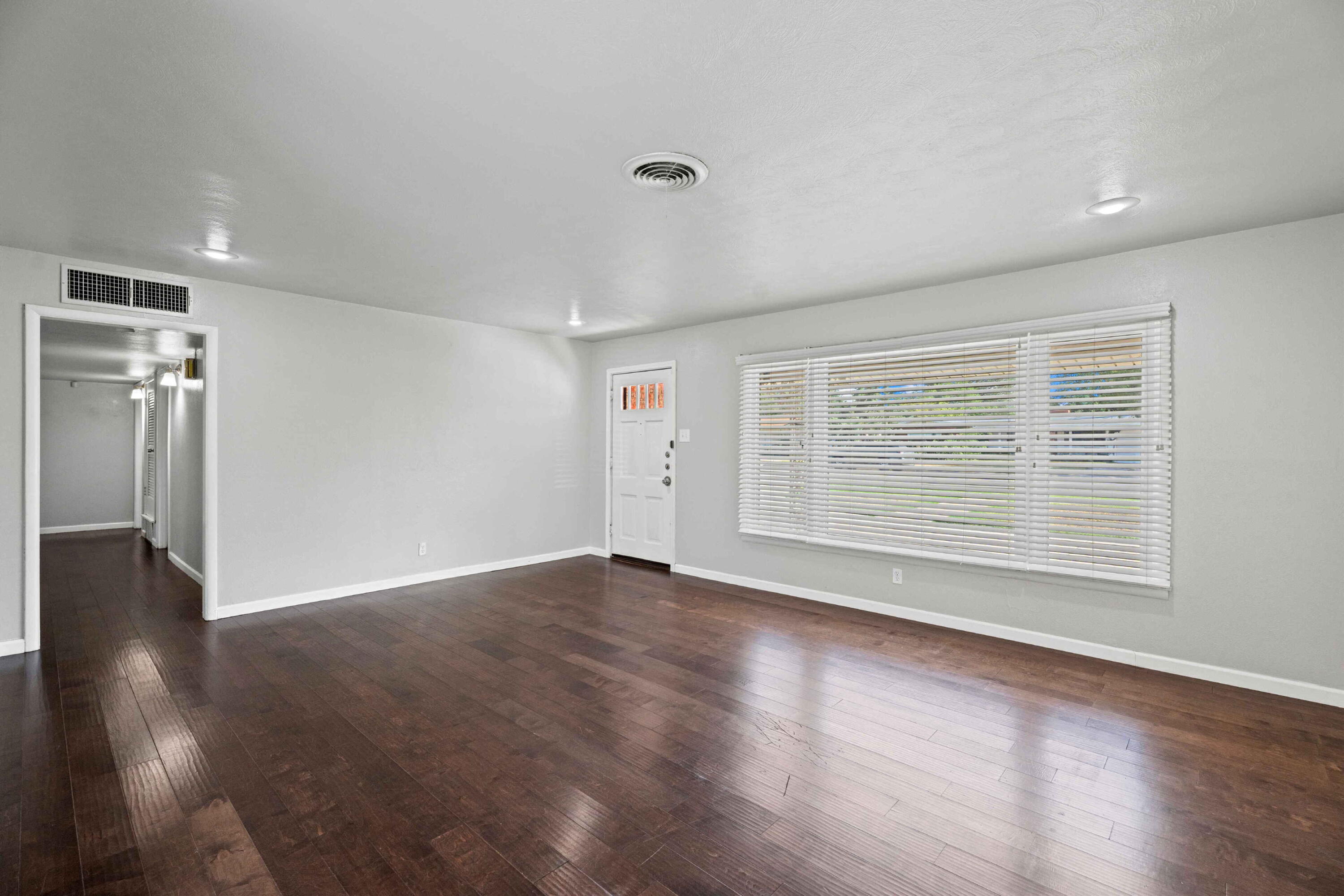3520 42nd Street Lubbock, TX 79413 - Photo 3 of 12 an empty room with wooden floor and windows