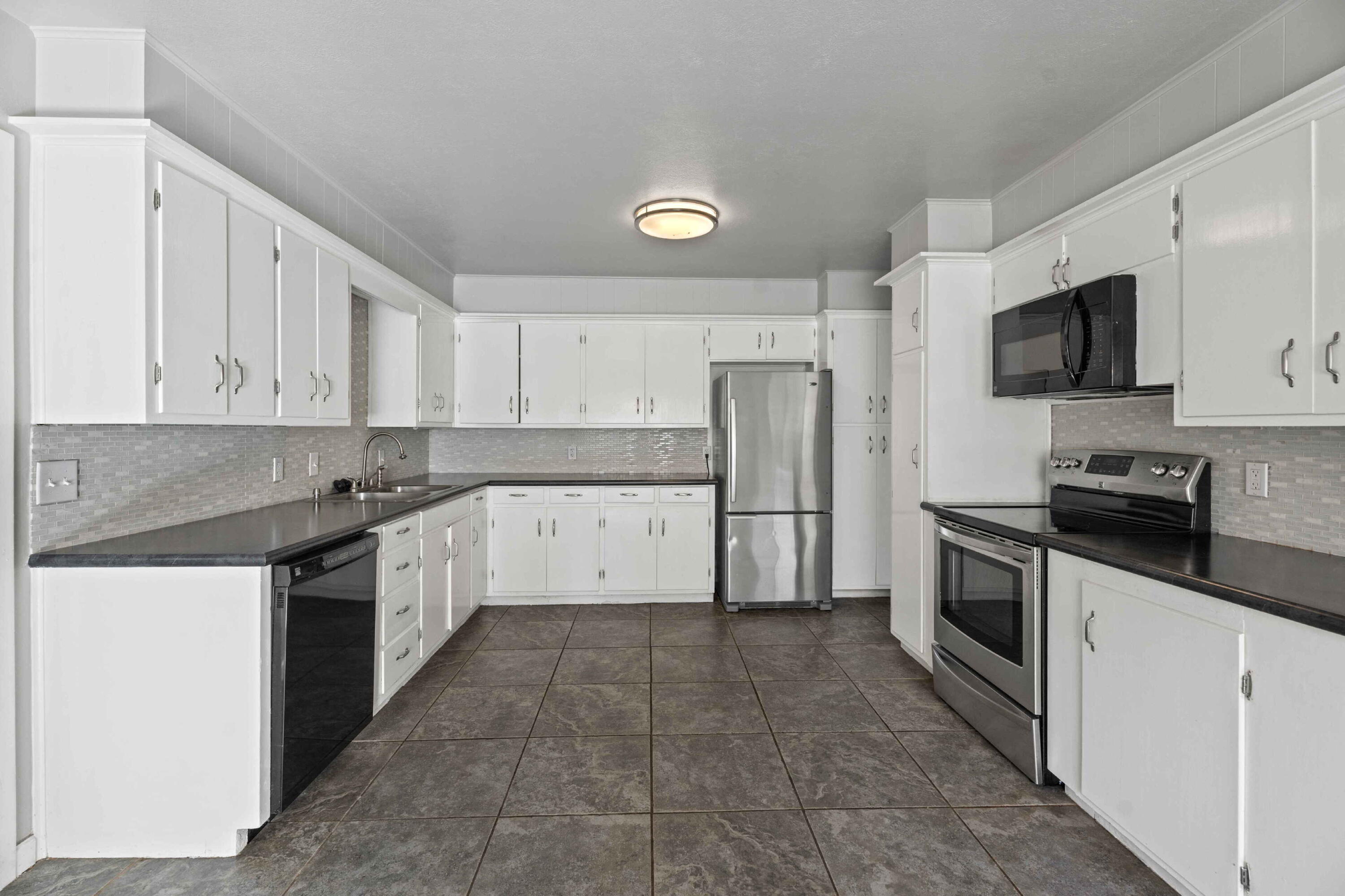 3520 42nd Street Lubbock, TX 79413 - Photo 5 of 12 a kitchen with a sink a stove and cabinets