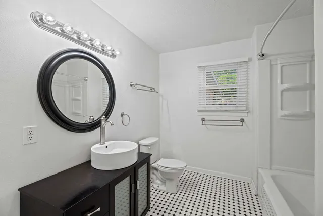 a bathroom with a sink a mirror and a toilet