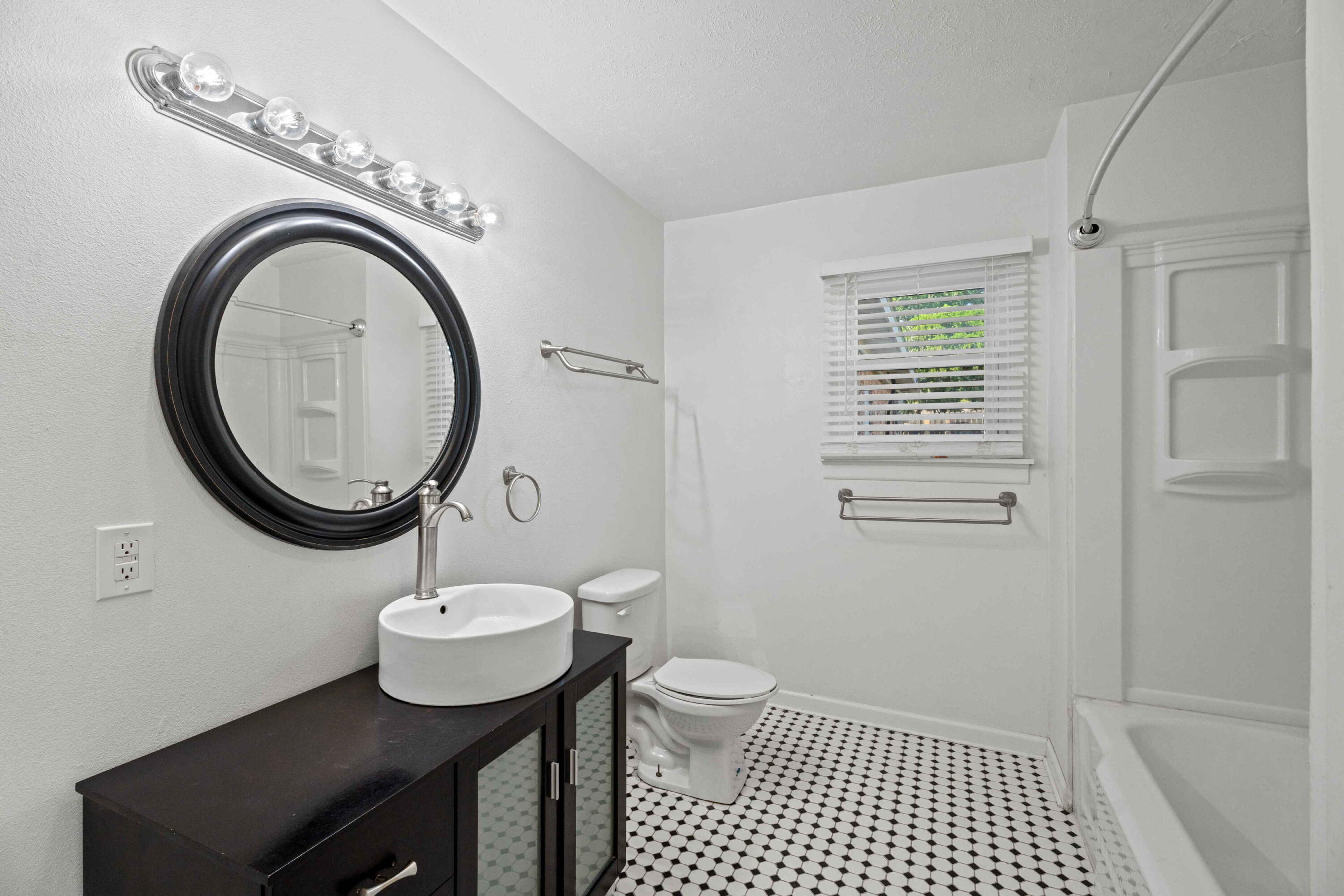 3520 42nd Street Lubbock, TX 79413 - Photo 9 of 12 a bathroom with a sink a mirror and a toilet