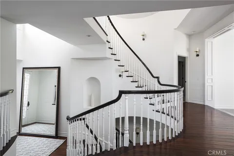 a view of staircase with lots of frames on wall and wooden floor