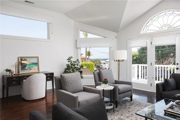 a living room with furniture a wooden floor and a large window