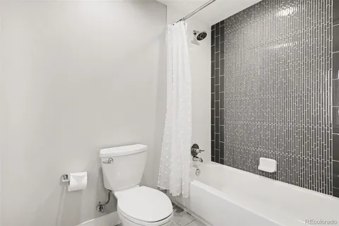 a white toilet sitting next to a white tub