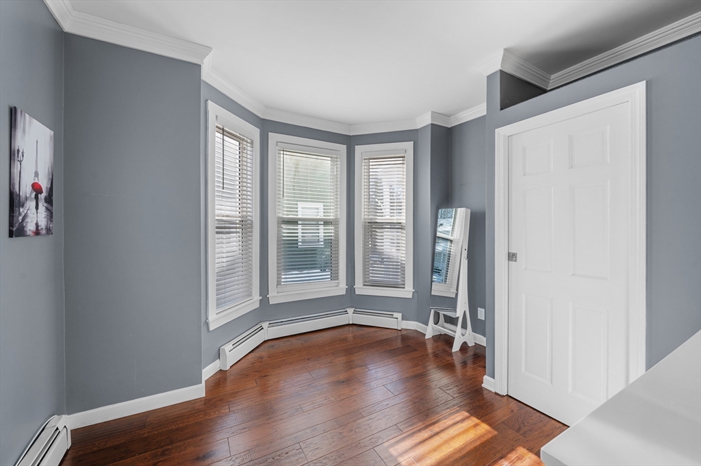 5-7 Vernon Street, Unit 1 Haverhill, MA 01835 - Photo 13 of 22 an empty room with wooden floor and a window