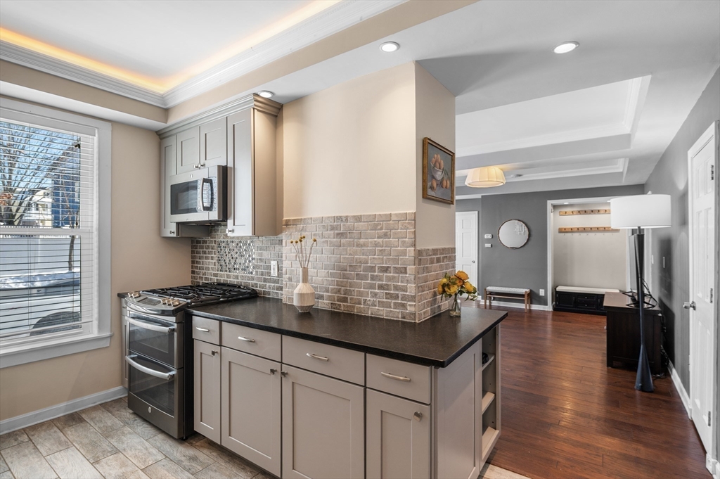 5-7 Vernon Street, Unit 1 Haverhill, MA 01835 - Photo 2 of 22 a kitchen with granite countertop a sink stove and cabinets