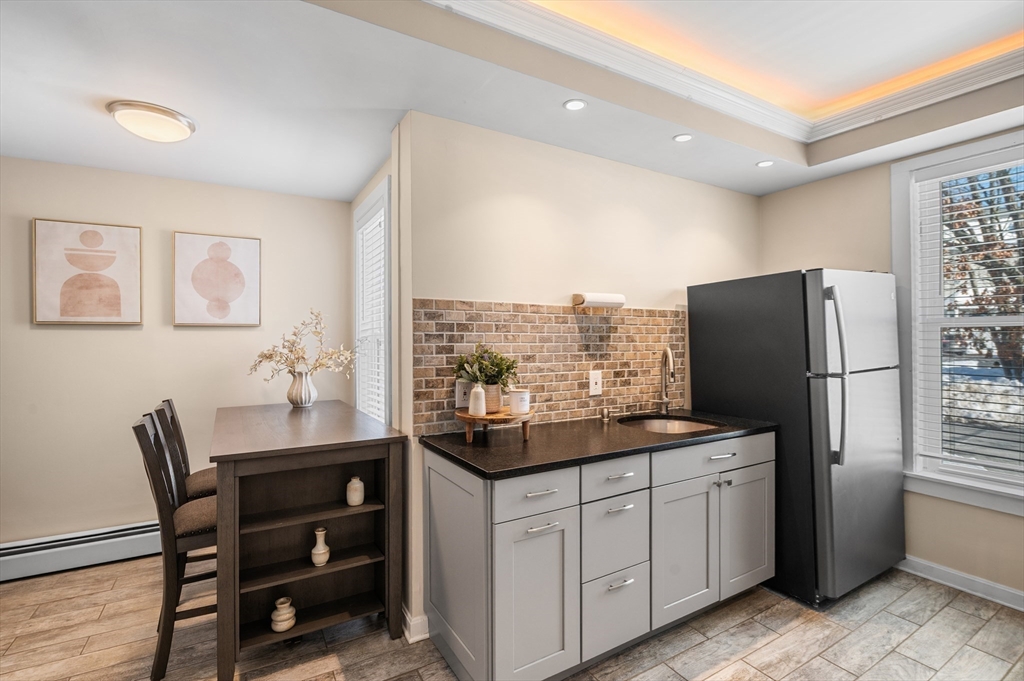 5-7 Vernon Street, Unit 1 Haverhill, MA 01835 - Photo 3 of 22 a kitchen with a table chairs refrigerator and microwave